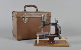2017.236.1 i Essex miniature sewing machine and attachѐ case.