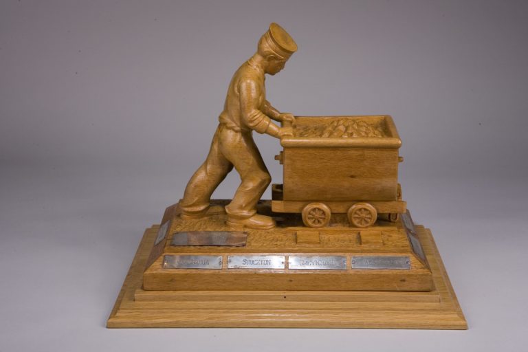 Carving depicting a rating pushing a coal truck.