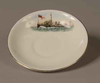 GEI-0022-Coffee-saucer-e1422843374265 Demi Tasse white porcelain saucer. Top of saucer is decorated with a picture of a World War One torpedo boat with a white ensign at the jack. Words on the saucer read: ‘H.M Torpedo Boat’.